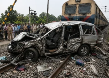 Murshidabad Level Crossing Accident scene showing a damaged school van near a railway crossing after a train collision, with railway officials, police personnel and rescue teams investigating the tragic incident.