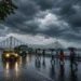 West Bengal Weather Update showing dark monsoon clouds, heavy rainfall over North and South Bengal, with people carrying umbrellas amid rainy weather and storm conditions.